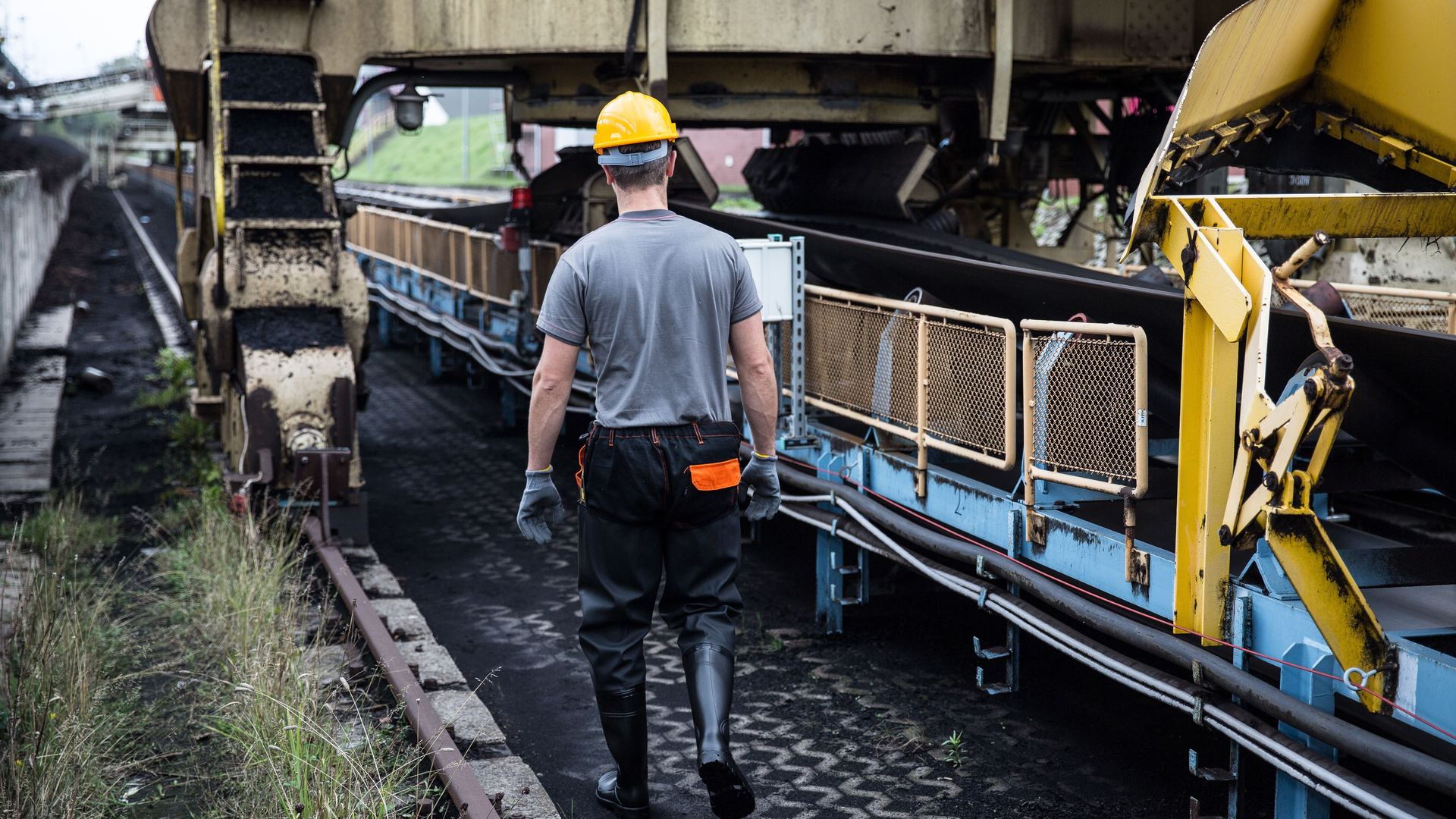 Operario con equipo de protección junto a maquinaria industrial — calculadora de indemnización por accidente laboral